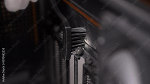 Closeup of skilled computer technician cleaning dusty computer case, focusing on each component for optimal performance and longevity. Concept of service for repair and cleaning computer, slow motion.