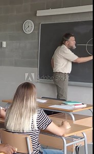Vertical video. Male math teacher explaining the lesson in a class of young students. High School, Students listening carefully to the lesson