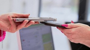 Two women use tapping cashless wifi qr code nfc scan app smart pos device reader sale in modern beauty clinic. NFC contactless technology.