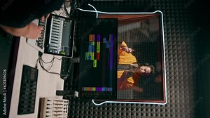 young pop rap artist emotionally recording a new song in a professional recording studio sound engineer watching tracks on the display vertical video
