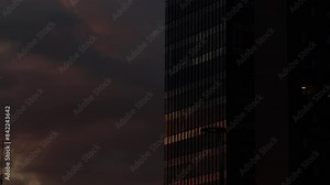 Glass modern office building time lapse. 4K time lapse video with the sunrise reflection in the glass wall of an office headquarters corporation building. Concept video for business working schedule.