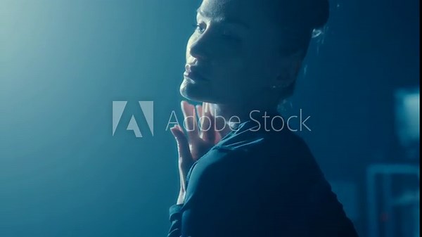 Artistic closeup side view of an elegant woman in backlight, moving gracefully in tight clothing, exuding confidence and allure.