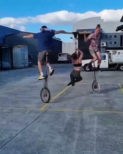 Trio of Acrobats Performs Traditional Unicycle Trick - 1201168