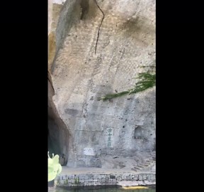 Tourist drops rock into pond to beautiful ripple reflection on rock face