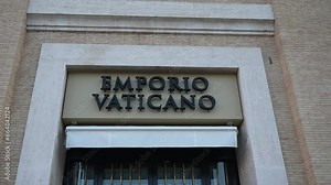Close-up low-angle view of street name sign of Emporio Vaticano on wall of old house in Rome, Italy, Piazza Pio XII. Concept of vacations and travel. Shooting in slow motion.