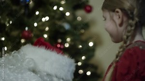 Santa Claus delivering presents to a young girl on Christmas eve