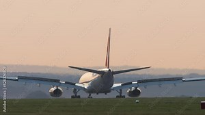 Sunset footage of a passenger plane braking after landing, rear view. Cinematic scene of plane arrival, slow motion. Tourism and travel concept