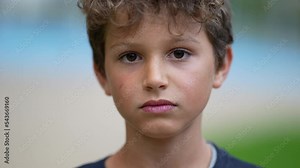 Angry young boy becoming serious. Portrait face kid changing emotional expression from happy to anger. Unhappy preteen child
