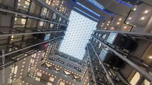 Moving up the escalator with glass sides and metal steps