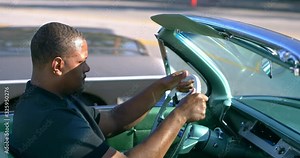 Black African American man behind the wheel driving classic car in Los Angeles, California, 4K