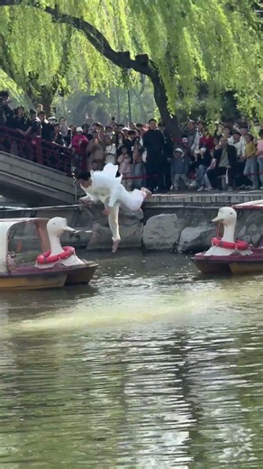 Performer jumps along rope over water during spring event in Hebei, China