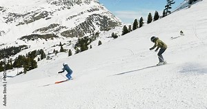 Cinematic downhill skiing show of a couple on a steep ski slope in beautiful mountain landscape. Slomotion skiing of two skier's in a nice formation with great skiing skills and good style. 4K