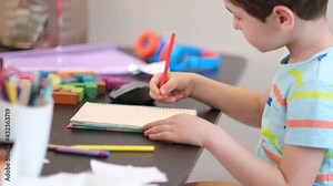 Learn on your schedule. Distance learning online education. A schoolboy boy studies at home and does school homework. A home distance learning.