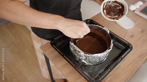 Pouring Melted Chocolate into the Prepared Crust, Ensuring Even Distribution. The Rich Chocolate Mixture Forms the Base Layer for the Cheesecake.
