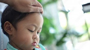 A father's hand is caressing his child's head.