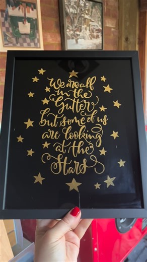 Katrin aka Colourful Kat! on Instagram: "After seeing the recent Banksy street art, this quote immediately came to mind: “We are all in the gutter, but some of us are looking at the stars.” — Oscar Wilde I’ve wanted to try a reverse glass gilded version of modern calligraphy for so long. The idea was there, but fear held me back — writing teeny tiny letters with brush and paint… and back to front! I think the result speaks for itself. 23ct gold leaf, hand-painted in reverse on glass. Calligraphy