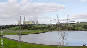Slow orbit around high-voltage transmission lines from coal-fired power station in the distance. Loy Yang thermal power plant generates base-load electricity for Australians using fossil fuels.