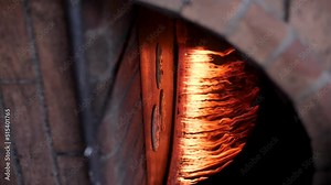 Putting traditional Arabic bread to bake inside a fire oven.