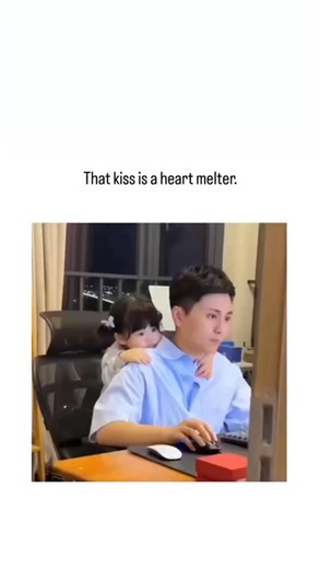 @brainly_dose on Instagram: "The post showcases a 16-second video of an Asian father working at his desk as his affectionate toddler daughter climbs on his back and plants multiple kisses on his cheek, captioned “That kiss is a heart melter,” amassing over 37,000 likes and 600,000 views within 24 hours. Replies overwhelmingly echo the sentiment with personal anecdotes of parenthood joy and shares of similar heartwarming clips, underscoring the post’s role in amplifying feel-good content on a pla