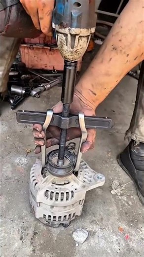 Dirty hands pull alternator pulley using gear puller