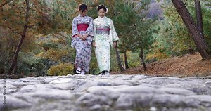 Pretty Japanese women walking on old stone path.