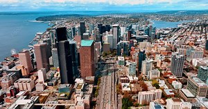Downtown skyscrapers stand out in the scenery of Seattle, Washington, United States. Blue waterscape of the lakes at backdrop. Top view.