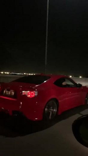 Sleek Red Sports Car Driving at Night