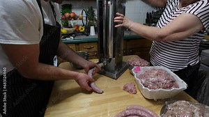 Home made sausages being slowly made using stuffer and fresh ground and marinated pork meat.