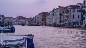 Colorful time lapse of the Venetian gondolier punting gondola through green canal waters of Venice Italy. Beautiful Venice time flow at sunset.