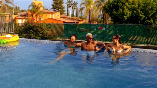 Aerial view of three individuals donned in bikini and sunglasses enjoying the sun at the pool - Free Stock Video