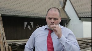 overweight man smoking a cigar, coughs and looks at camera