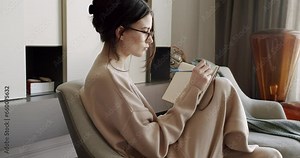 Attractive Woman freelance writer is writing his article on a notebook. idea and inspiration concept. Businesswoman writes startup business ideas and plans, creative thoughts to notebook.