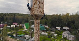 industrial climbers paint the iron tower. Risky job. Extreme work. Worker alpinist.