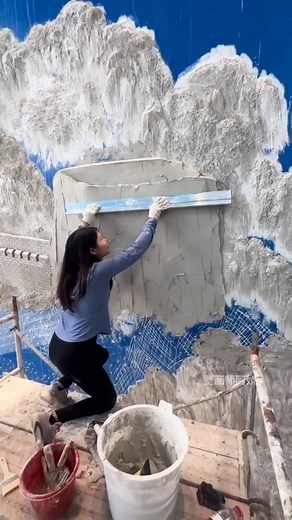 There’s something magical about the way she works—building entire worlds from both depth & detail. She doesn’t just paint murals; she sculpts them. Using layers of plaster, she creates shapes that rise from the wall, giving her art a bold, tactile dimension that literally pops out at you. Once the plaster dries, she brings it to life with paint, transforming texture into emotion & structure into story. Her murals don’t just hang on a surface—they emerge, breathe, & invite you to step closer. A t