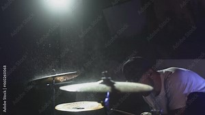 Water droplets from hitting the drum fly into slow motion, crash, ride and snare drum. Night show in a musical instrument recording studio. The drummer knocks and beats, Repetition of rock music band
