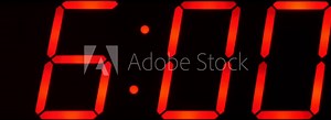 Close up of huge black,dark clock digital display,screen showing time between 6:00 AM or PM and 6:59 and beyond in big red digits