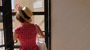 Young woman opens the back door wearing red dress and a hat. Back door open from inside Stock Video