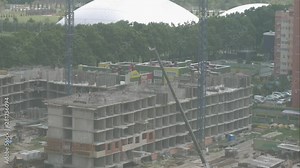 Timelapse video of construction site in beginning of building new housing project. Workers and machinery move fast and busy on development area. Construction site with motion cranes and trucks.