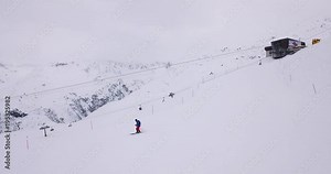 Skiers rush down the pistes of a mountain ski resort in Andermatt in Switzerland