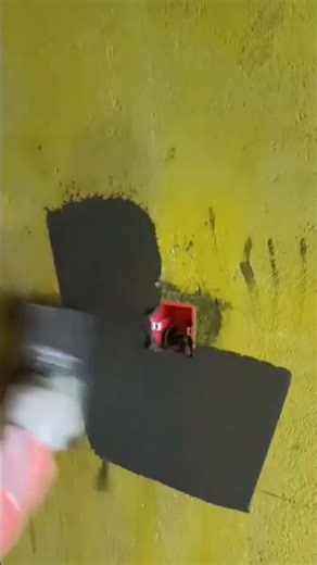 Electrician Applies Grey Cement To Install Yellow Wall Box