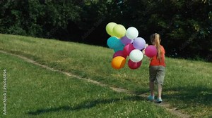 Girl running away from camera with balloons
