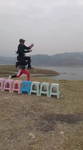 Playful Outdoor Jumping Challenge Over Colorful Stools