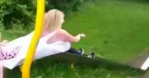 Earth, swallow me: A woman loses her top while going down a slide!