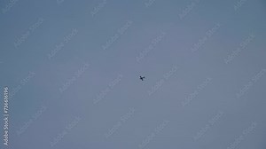 Light aircraft flying. Vintage plane soars in sky. Light engine pleasure plane flies high in blue cloudy sky. Propeller old plane in air. View from the ground, below
