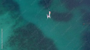 Top View Of Catamaran Boat With Colorful Sail Cruising Across Caribbean Sea In Bayahibe, Dominican Republic. aerial