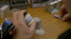 Worker deals with tedious shaping of the dental model made of wax material. Using a small tool to shape the dental wax. Finishing the denture replacement production by shaping the dental wax.