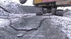 The excavator goes and pulls the electric cable. Heavy excavator in the mine receives energy from the electrical cable.