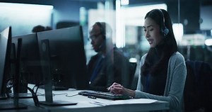 Customer Support Professional Using Computer and Talking with Client on a Call. Asian Help Desk Employee Responds to Queries, Resolve Problems and Troubleshoot Issues, Implement Solutions