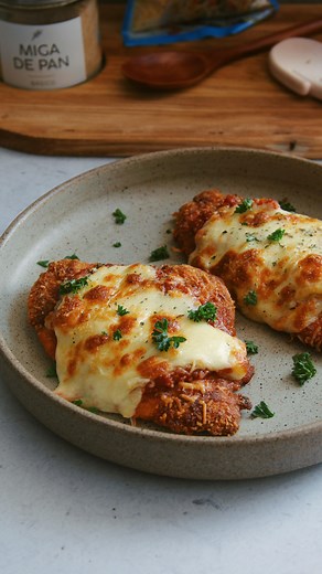¡Milanesa de pollo gratinada con Queso Parmesano Alpina y salsa pomodoro, una delicia de almuerzo!🍗😮‍💨🧀 Comenzamos haciendo una mezcla de harina, sal, pimienta y ajo en polvo, y por ella vamos a pasar los filetes de pechuga de pollo que previamente aplanamos un poco, te recomiendo que la dejes de 1/2 cm de grosor. Batimos dos huevos con sal y finalmente hacemos una mezcla de partes iguales de miga de pan y queso Parmesano @alpina que le va a dar un toque crujiente único y va a potenciar su s