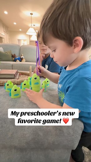 Watch as my three-year-old plays "Reel Big Catch," a fishing game that combines fun with learning. In this game, players use a fishing rod to carefully hook fish by their mouths, testing their fine motor skills and coordination. Once a fish is hooked and pulled up, its fin unfolds to reveal segments that indicate whether the fish is short or long, introducing early math concepts like measuring and comparing lengths. Throughout the game, he and his brothers take turns, enhancing their social skil